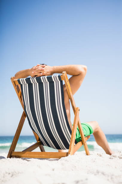 istock Man sitting and relaxing on deck chair 674505554