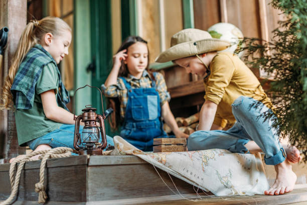 istock cute kids playing treasure hunt with map on porch 674505872