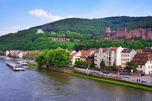 Embankemnt of Neckar river and the ship on the water in Heidelberg in  Baden-Wurttemberg in Germany. People on the background