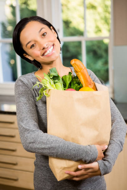istock Smiling brunette holding grocery bag 674521560