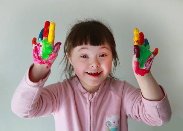 istock Cute down syndrome girl with painted hands 674526766