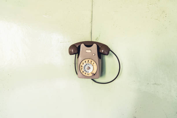 vintage phone on the wall - objects and places lost in time stock photo
