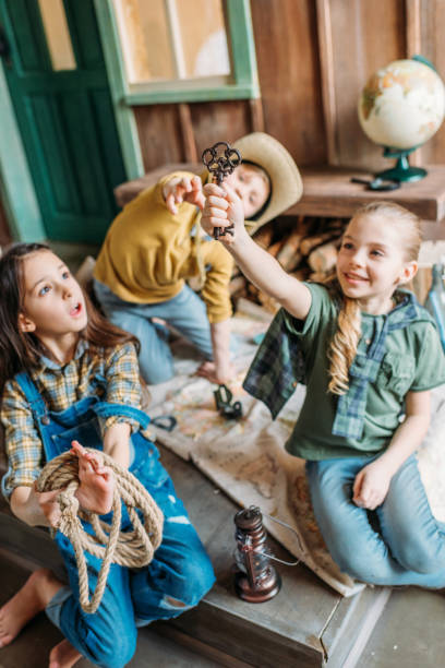 istock cute kids playing treasure hunt with map on porch 674528774
