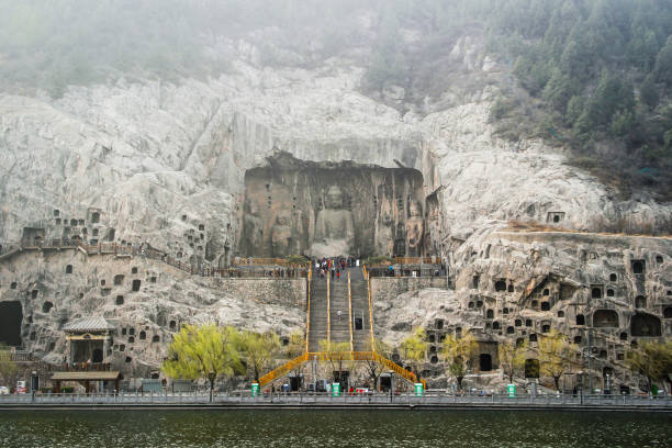 резьба по скале в гротах лонгмена, луоян, хэнань, китай - luoyang стоковые фото и изображения