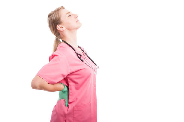 Female medical nurse holding her back like hurting stock photo