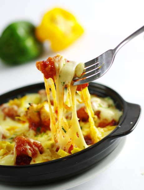 Fried chicken with cheese and chili in black pan in white background