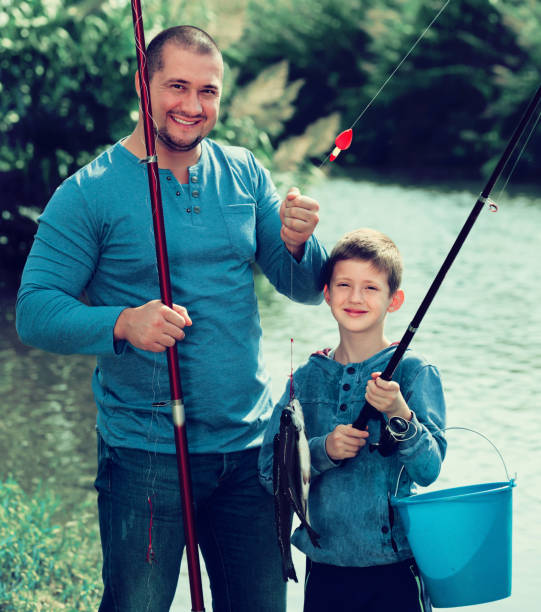 istock Glad father and son fishing with rods 674550048
