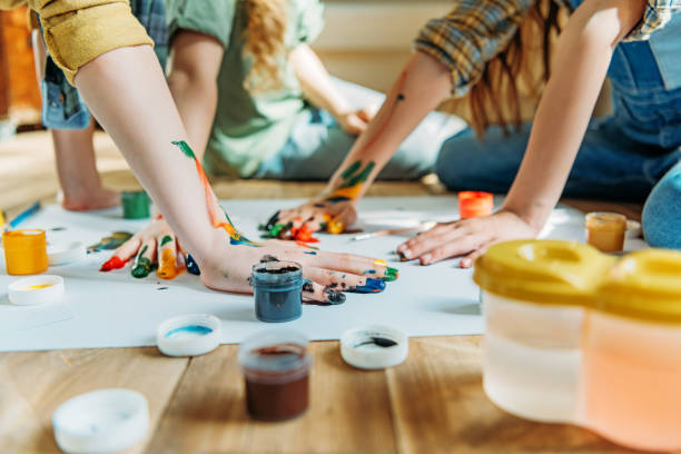 istock cute kids painting on paper with hands while sitting on floor 674554952