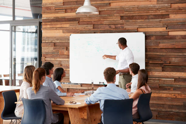 istock Young black man at whiteboard giving a business presentation 674555306
