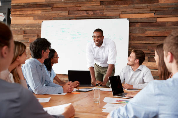 istock Young black man stands addressing colleagues at a meeting 674555316