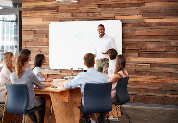 istock Young black man at whiteboard giving a business presentation 674555318