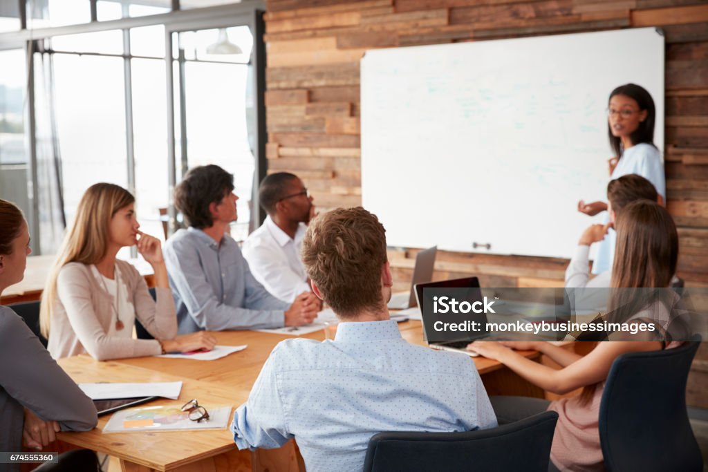Young black woman presenting to colleagues from whiteboardÂ Education Training Class Stock Photo