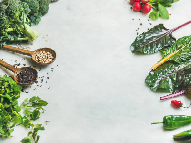 istock Fresh raw greens, vegetables and grains over marble countertop 674558196