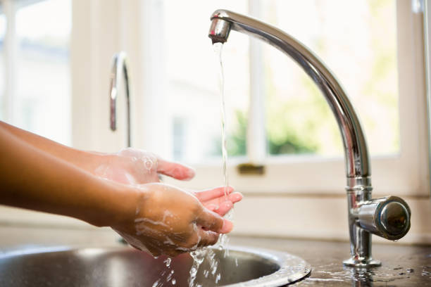 istock Mid section of woman washing hands 674561648