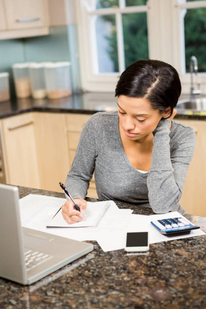 istock Worried brunette counting bills 674563892