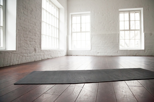 Espacio en blanco vacío, estudio loft, estera de la yoga en el piso photo
