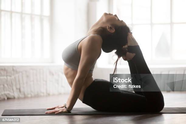 Young Attractive Woman In King Cobra Pose Loft Studio Backgroun Stock Photo - Download Image Now