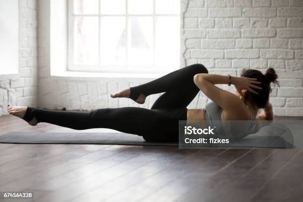 Young Attractive Woman Doing Bicycle Crunches White Loft Studio Stock Photo - Download Image Now