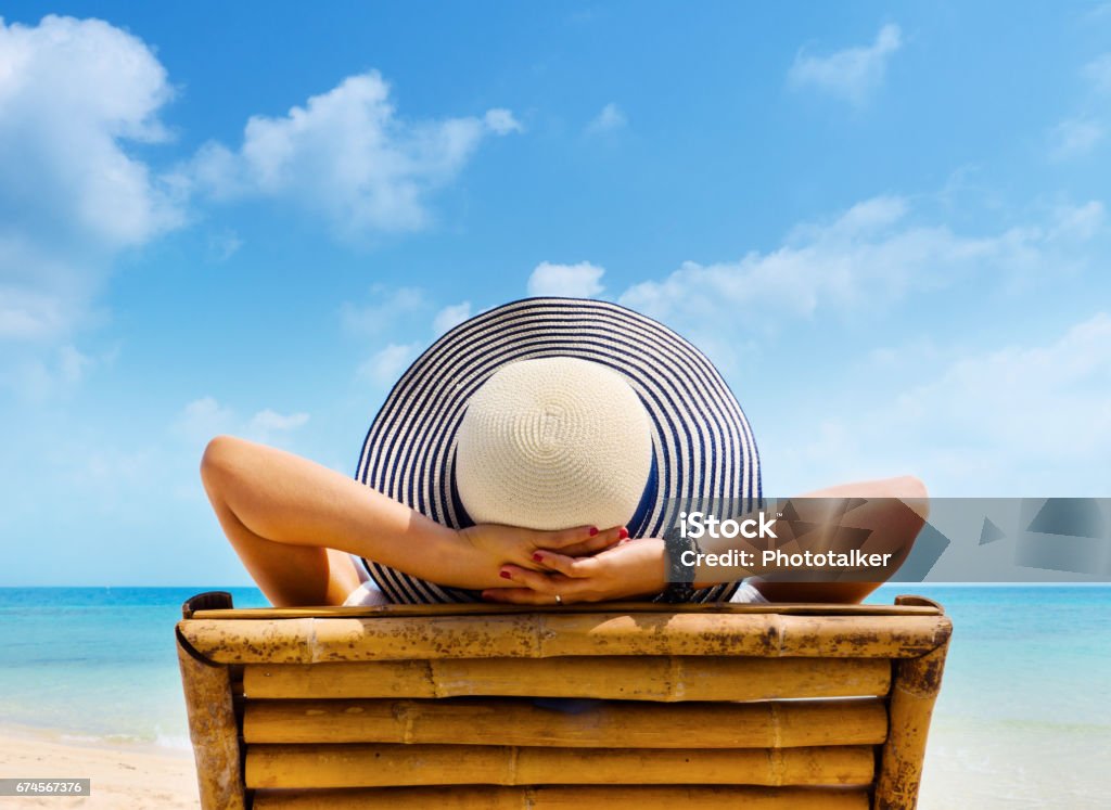 Woman in hat relaxing on beach, looking at sea. Copy space. Beach Stock Photo