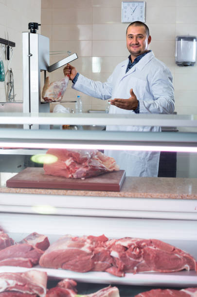 istock Man seller at the counter with meat 674571114