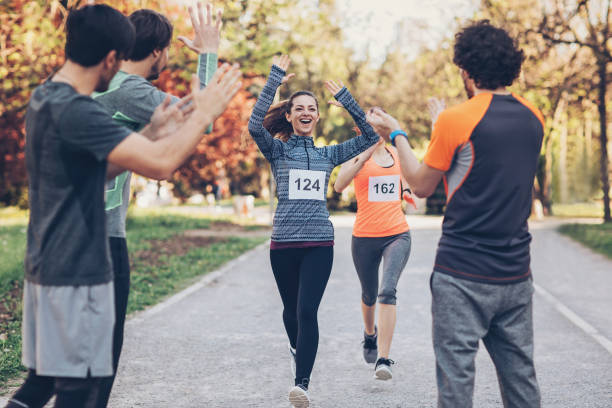 istock Beautiful runner greeted by the team at finish line 674571258