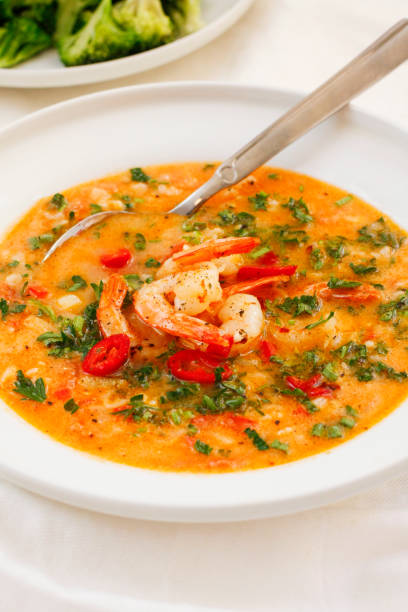istock Hearty tomato soup with prawns on white platter 674574962