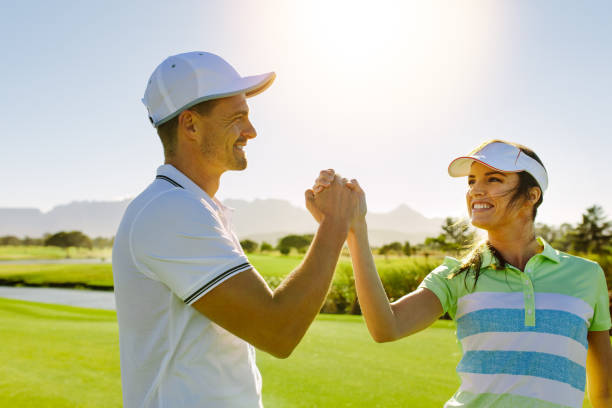 istock Male and female friends giving high-five at golf course 674575128