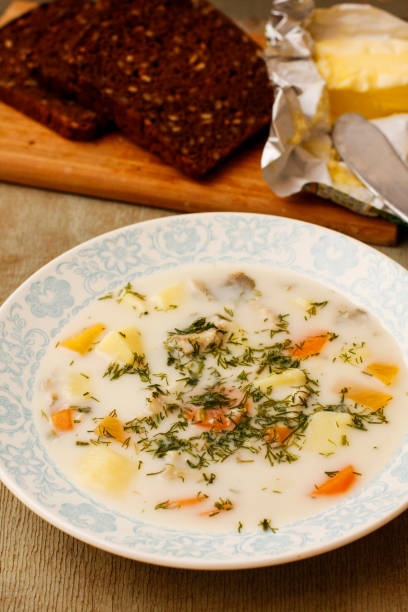 istock Fish soup with cheese spread on white dish with black bread 674578812