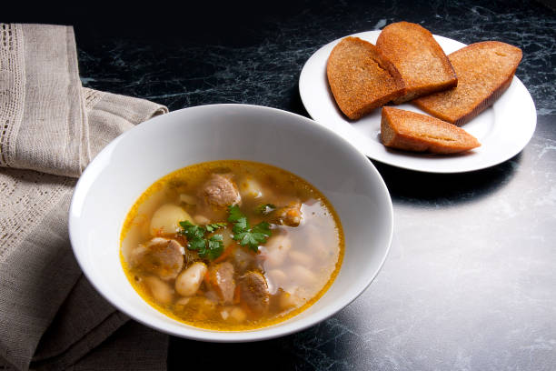 istock Bean soup in white plate, several toast on white plate 674578860