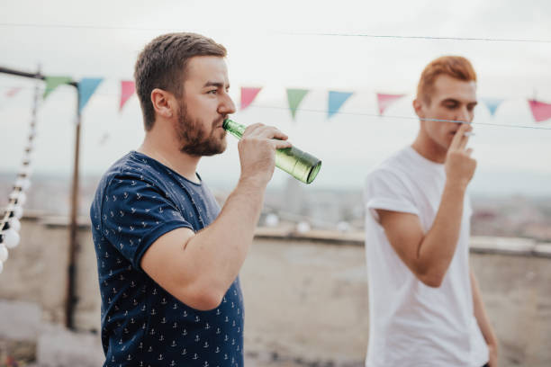 istock Boys hanging out on the roof and drinking beer 674579084
