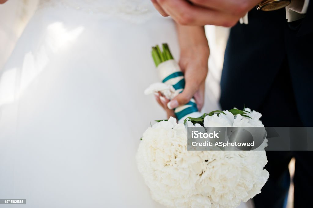 Wedding bouquet of white carnation at hand of bride Adult Stock Photo