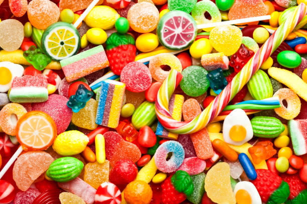 Colorful candies background Top view of colorful candies, jellybeans and lollipops background. DSRL studio photo taken with Canon EOS 5D Mk II and Canon EF 100mm f/2.8L Macro IS USM sugar food photos stock pictures, royalty-free photos & images