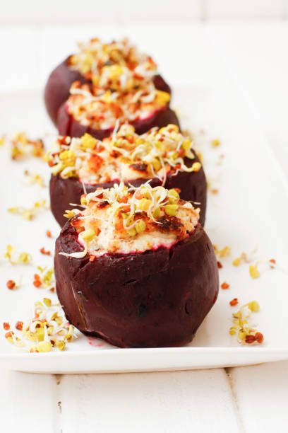 istock Baked beets with cheese filling and sprouts on white dish 674589084