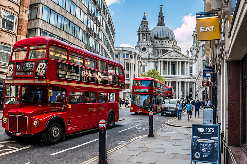 London: Busy street in central London, with classic retro and new modern double decker buses and St. Paul's Cathedral in the background. HDR style image