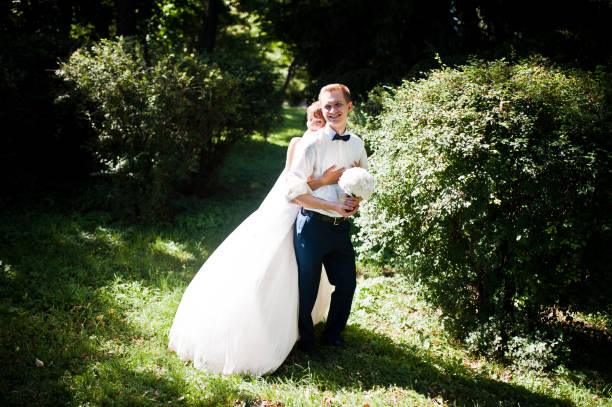 istock Wedding couple at park near trees and bushes 674589122