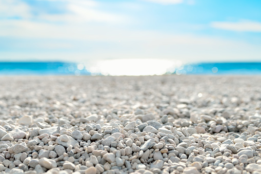 Low-angle shot of a beautiful white pebble beach at the mediterranean coast on a beautiful day.