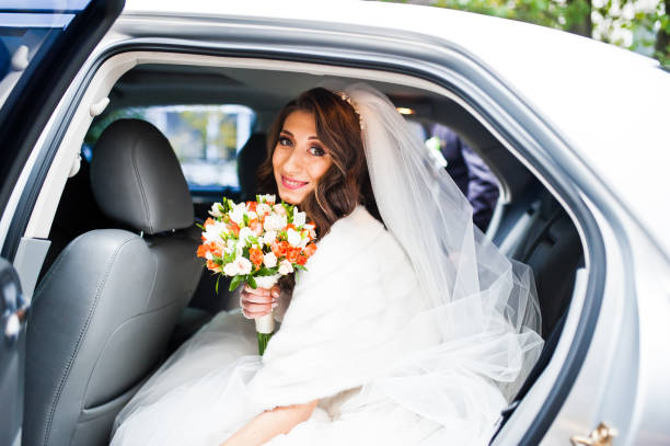 istock Cute curly bride looking from elegant wedding car 674595228