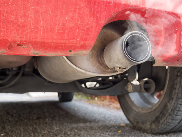 istock Diesel exhaust, old red car. Detail. With smoke. 674595366