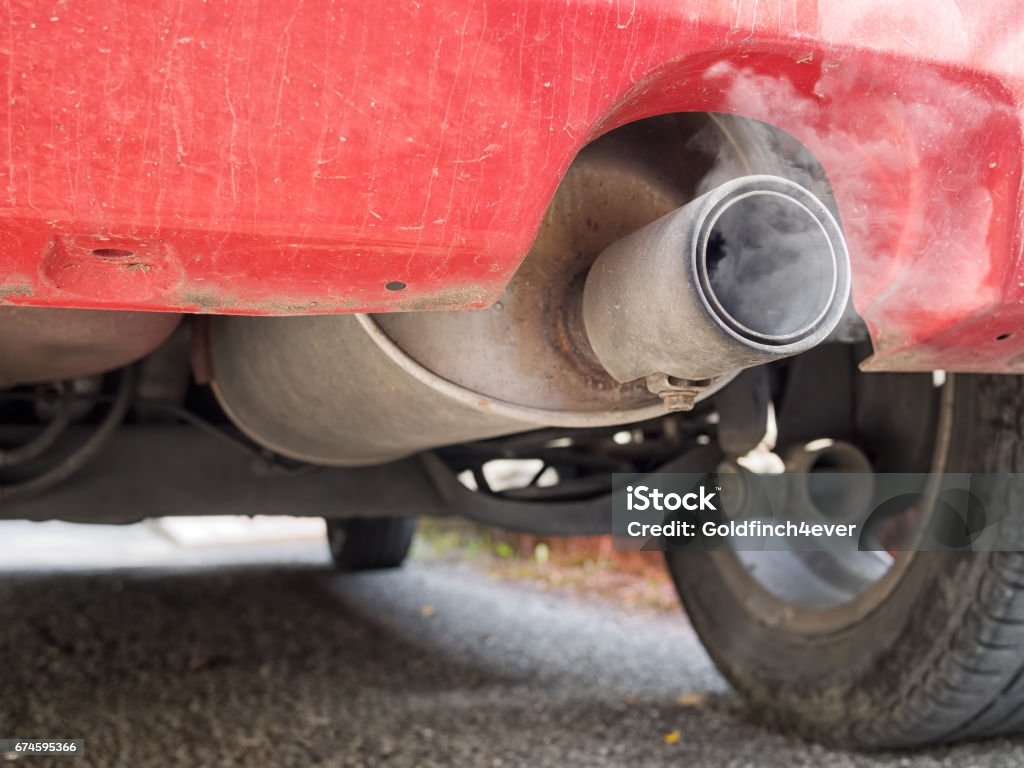 Diesel exhaust, old red car. Detail. With smoke. Now deemed environmentally unfriendly. Visible soot. Car Stock Photo