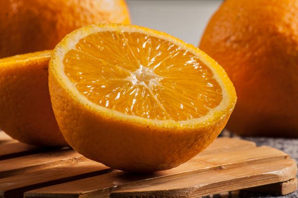 istock The orange cut in half on a wooden table. 674595698
