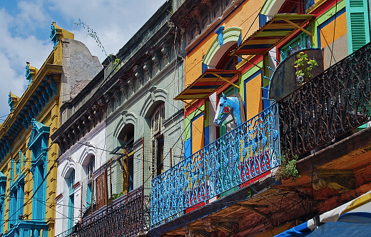 Facades on diagonal. Colorful simple ghetto balcony colonial style. Blue Iron parapet. Blue horse head on the wall.
