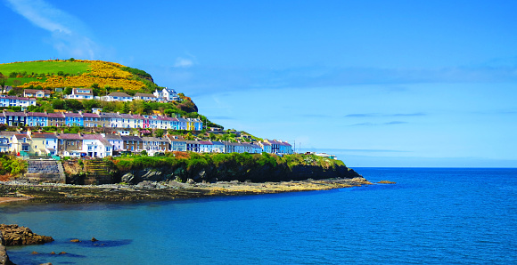New Quay - 'Cei Newydd', picturesque houses, pubs and restaurants cling to the hills rising above the blue waters of Cardigan Bay - West Wales coast holiday resort for sailing, fishing, water sports