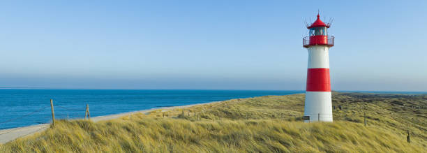 istock Red and white Lighthouse on sand dunes, Island Sylt, Germany 674603324