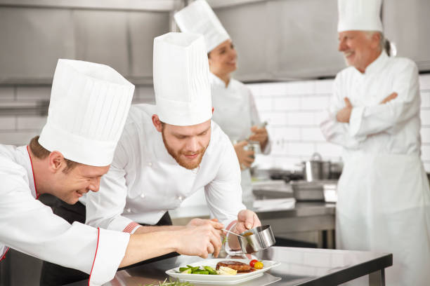 istock Two male chef preparing steak plate 674612494
