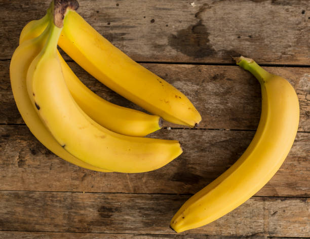 istock banana bunch on Wooden background 674615818