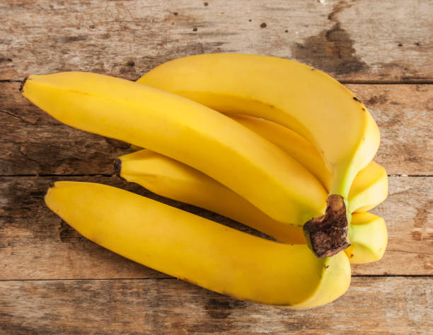istock banana bunch on Wooden background 674615876