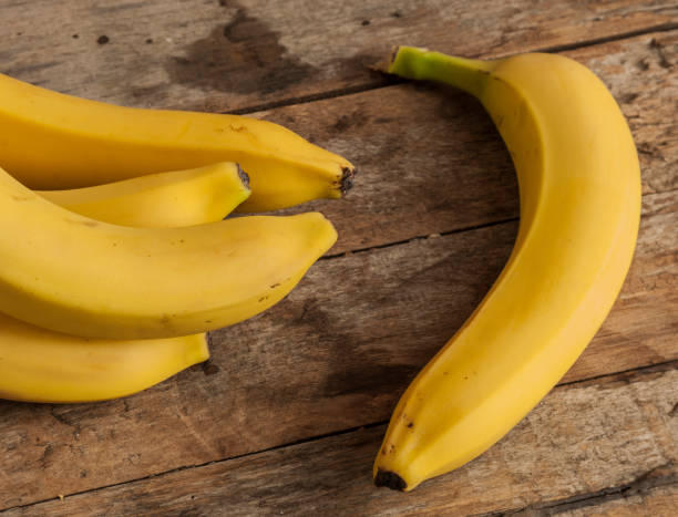 istock banana bunch on Wooden background 674615890