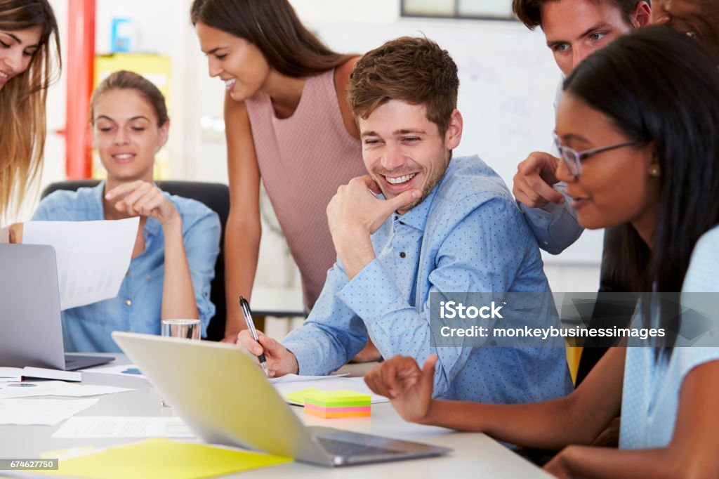 Colleagues working together in a busy office, close up Millennial Generation Stock Photo