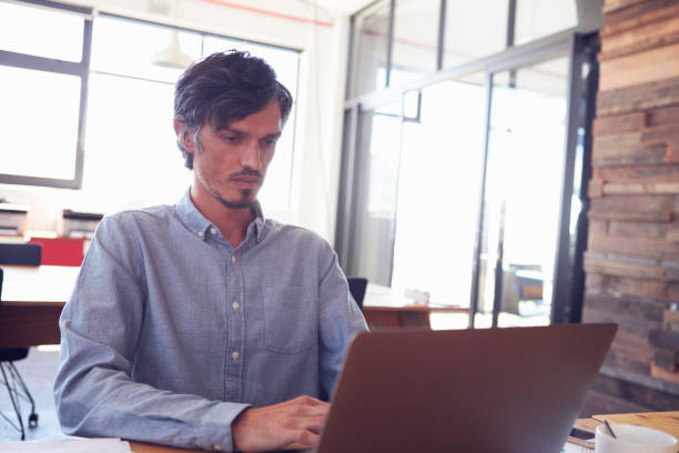 istock Mid-adult white man working in an office using laptop, close up 674627870