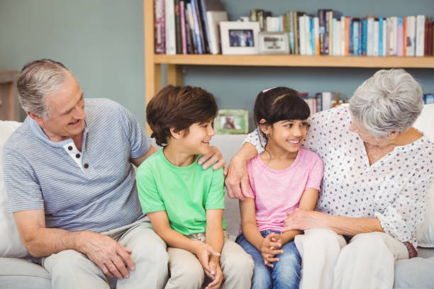 istock Grandchildren with grandparents on sofa 674631696